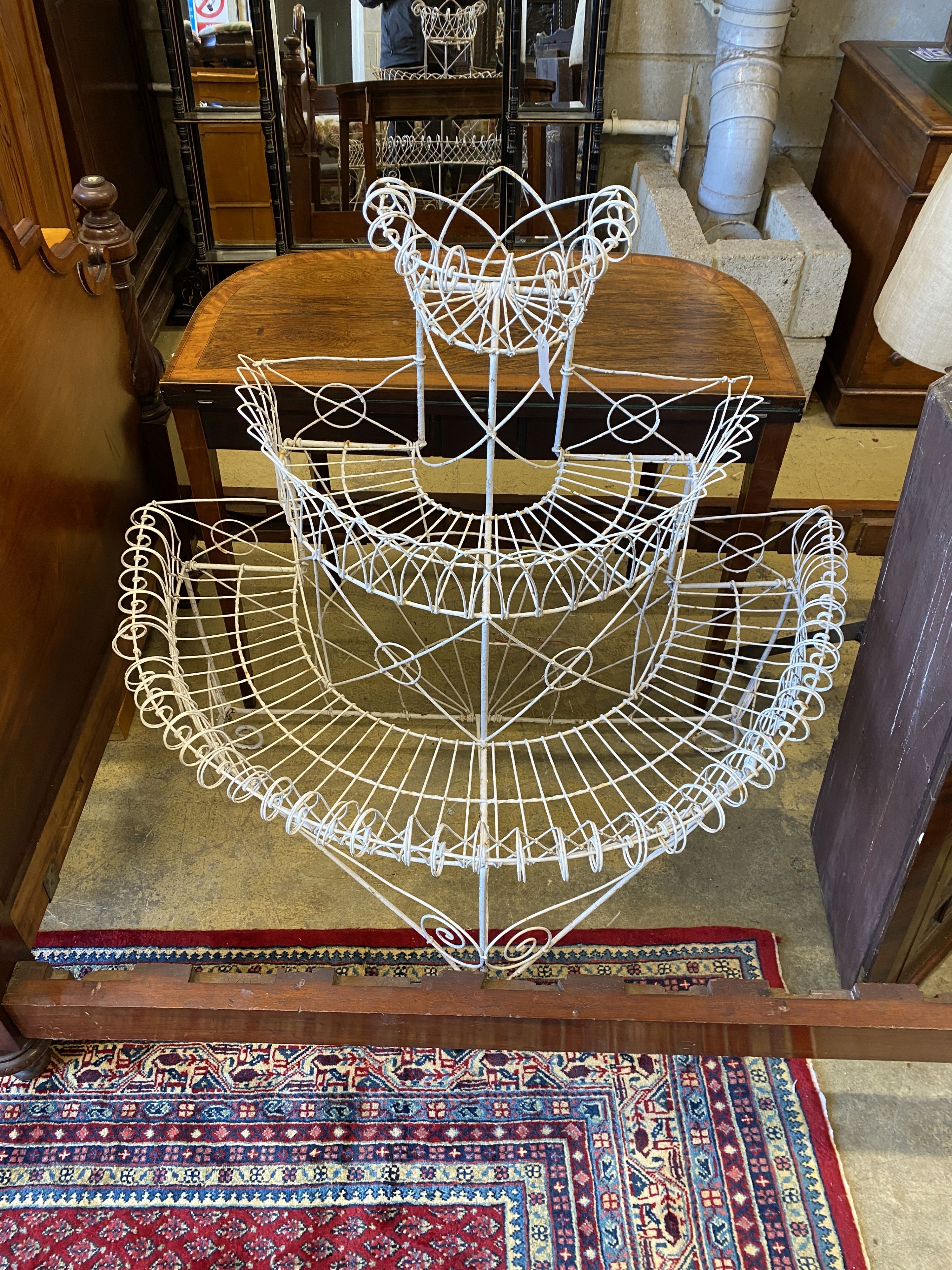 A Victorian wirework bow front three tier pot stand, width 104cm, depth 60cm, height 107cm